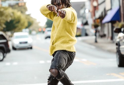 man in yellow top point fingers at the camera