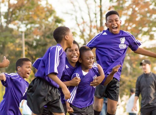 A group of children celebrating a football win