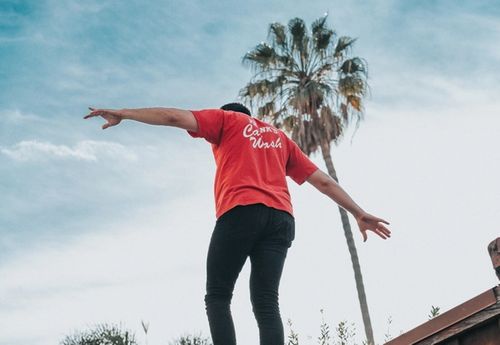 man walking on the edge of balcony