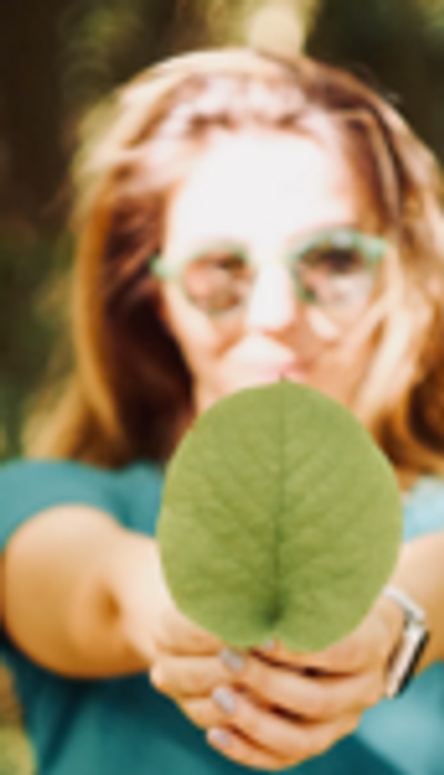 Woman holding a leaf to camera