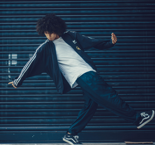 Man in casual clothing street dancing in front of a build shutter